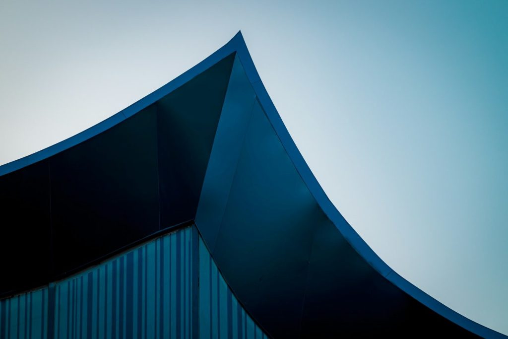 A building with a curved roof against a blue sky