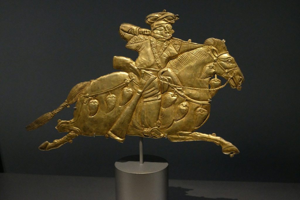 a gold statue of a man riding a horse