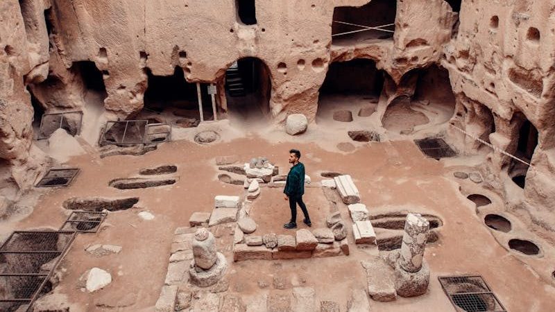 Person exploring the historic Gumusler Monastery ruins in Niğde, Türkiye.
