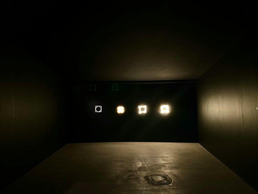 An artistic display of illuminated geometric shapes in a dark room setting.