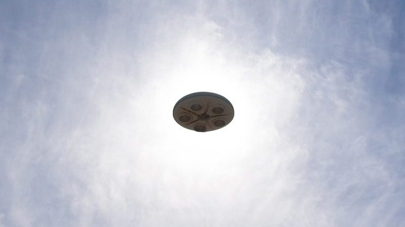 a frisbee flying through the air with a blue sky in the background