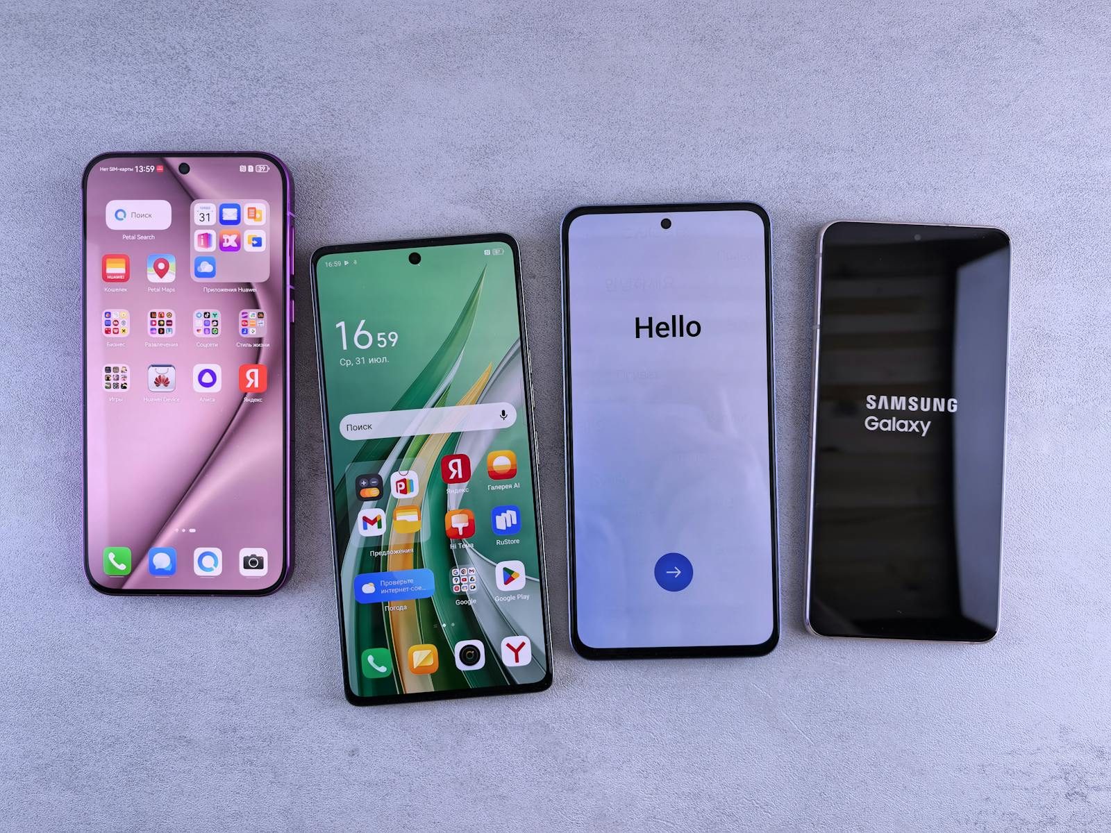 Four modern smartphones showcasing home screens, applications, and startup logos on a sleek surface.