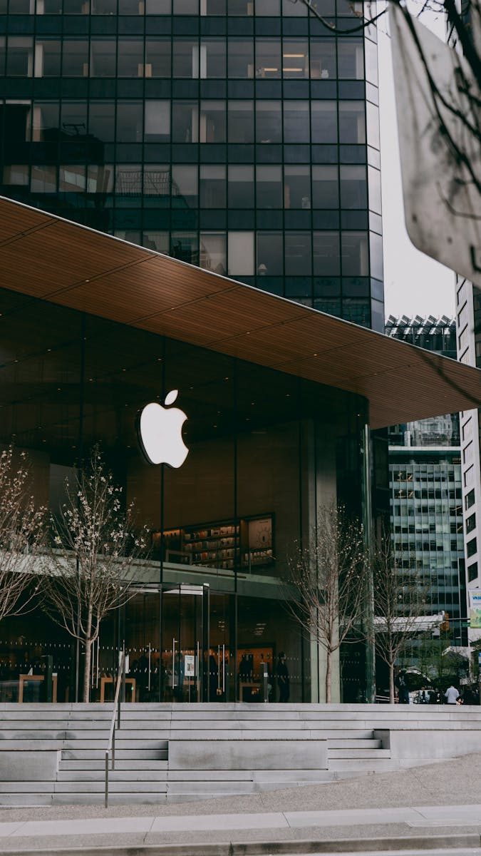 Exterior of a contemporary Apple store with sleek glass facade in urban setting.