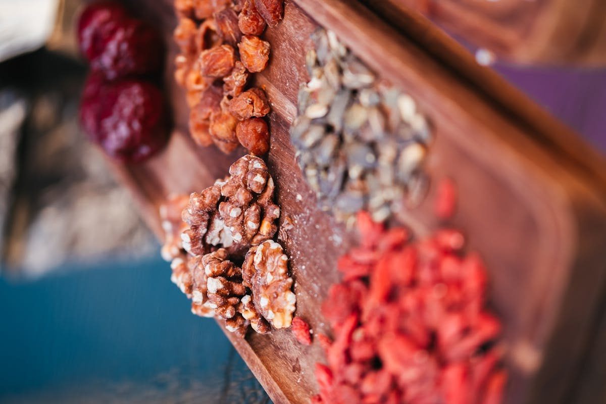 Close-up of assorted nuts and berries on a wooden tray highlighting healthy eating.