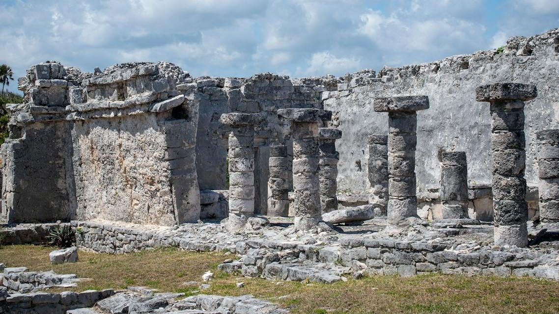 Explore the ancient Mayan ruins of Tulum under a clear blue sky.