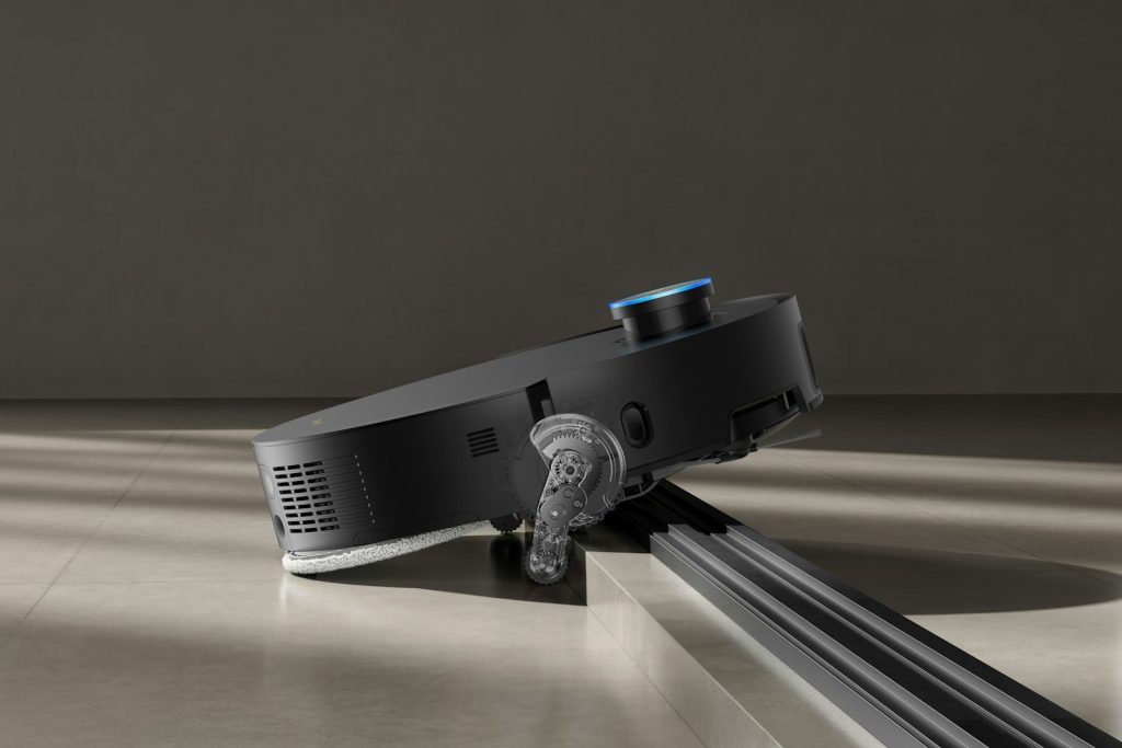 A black robot vacuum cleaner on a light gray floor.