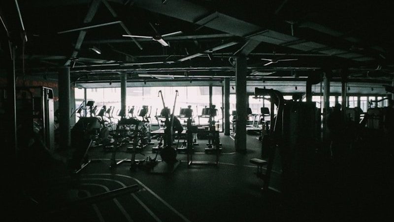 Dark gym interior with exercise equipment visible