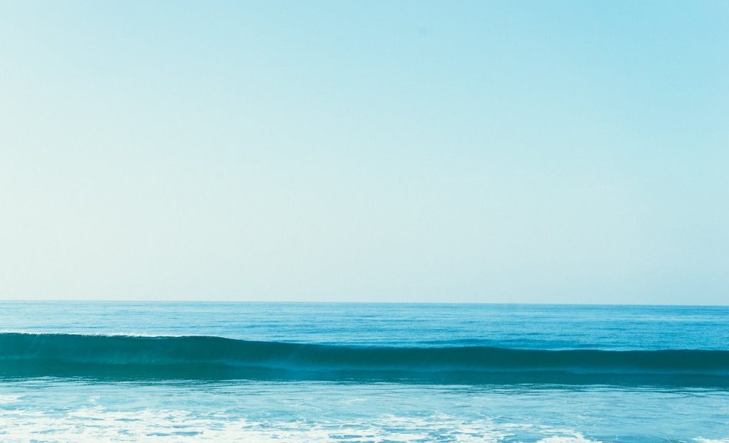 Tranquil ocean scene with gentle waves and a clear blue sky. Perfect for nature backgrounds.
