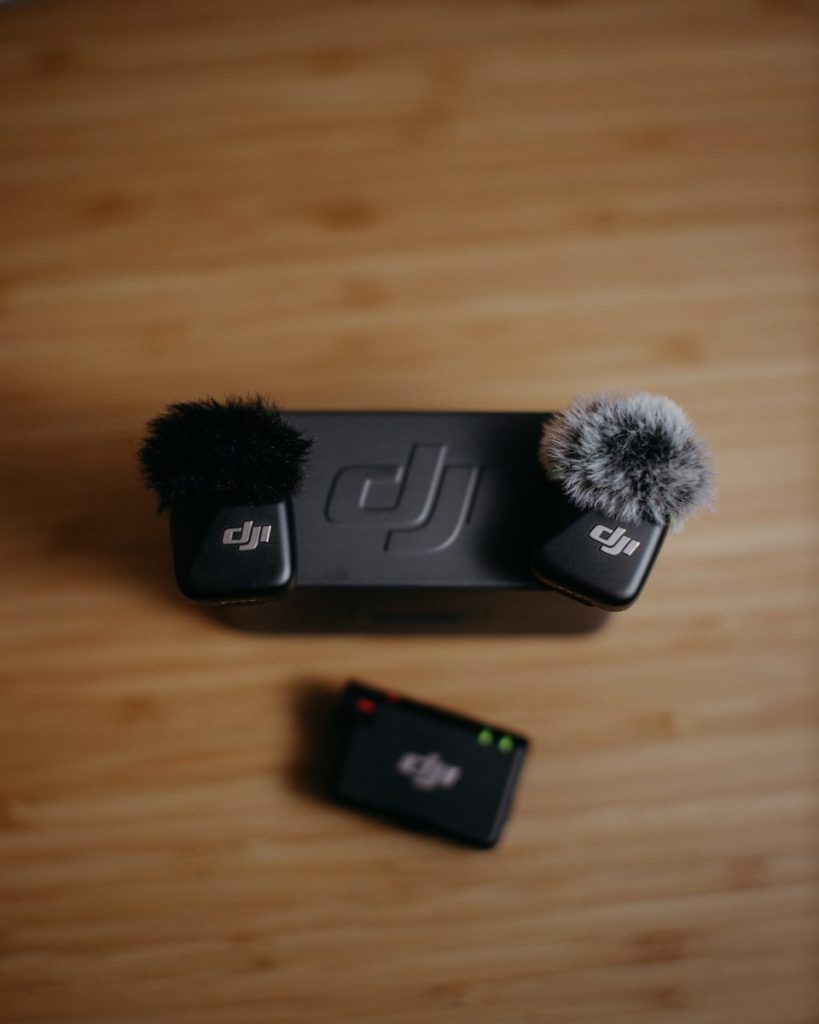 Dji microphones and receiver on wooden surface.