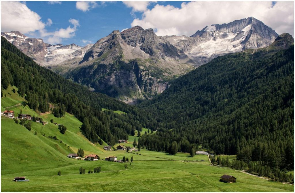 Breathtaking view of a lush green valley surrounded by majestic rocky mountains.