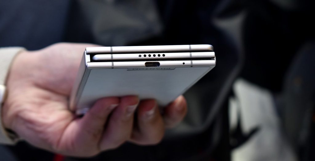 Person holding a silver foldable smartphone
