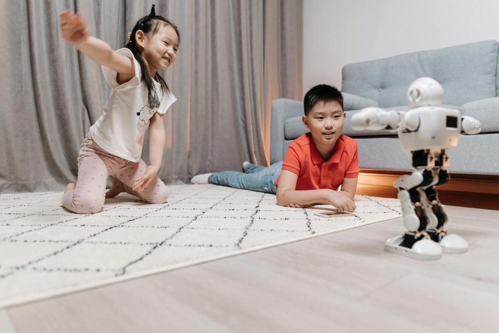 Two children enjoy playing interactively with a robot in a cozy living room setting.