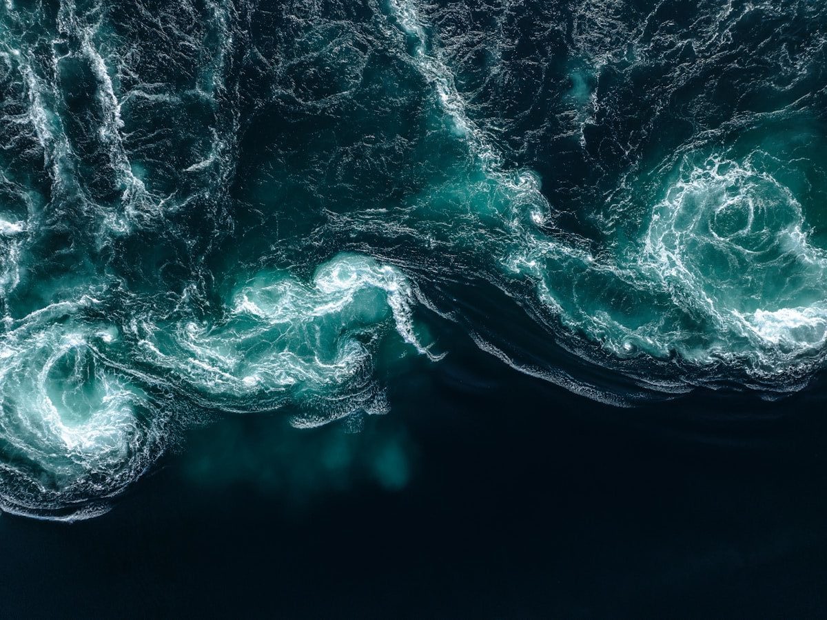 Turbulent ocean water with swirling currents and frothy currents.