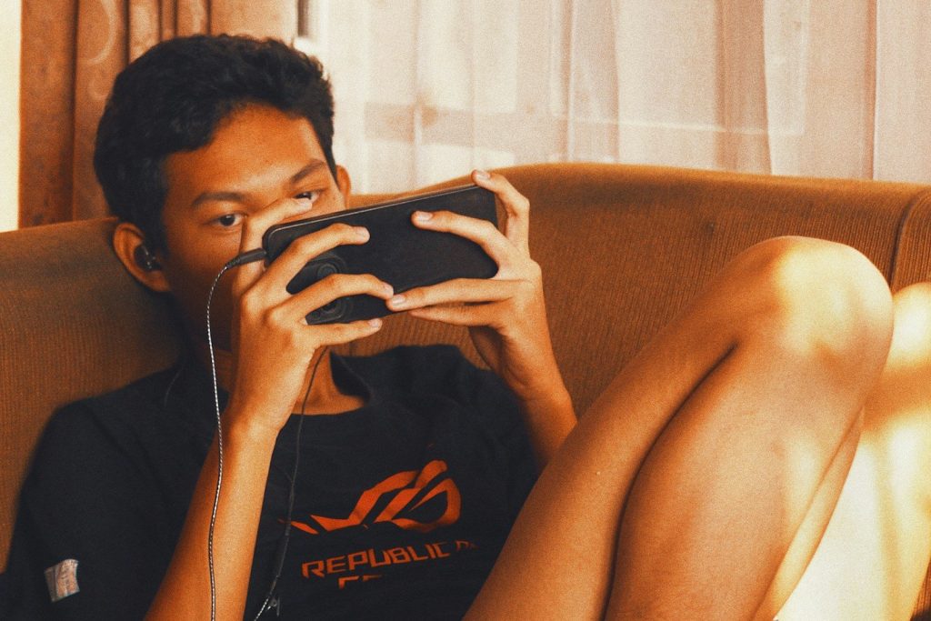 A young man is focused on his mobile game.