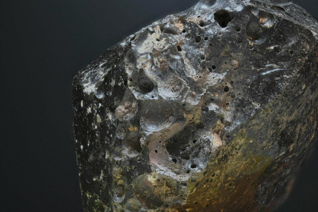 A rock with holes in it on a black background