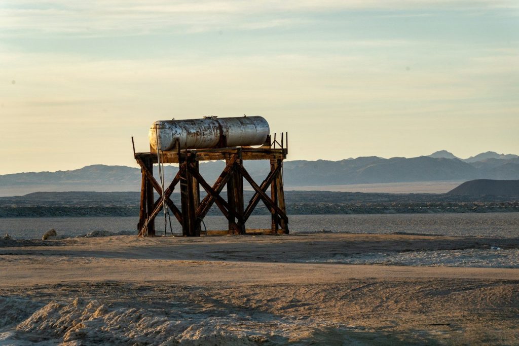 An old water tank stands in a dry landscape.