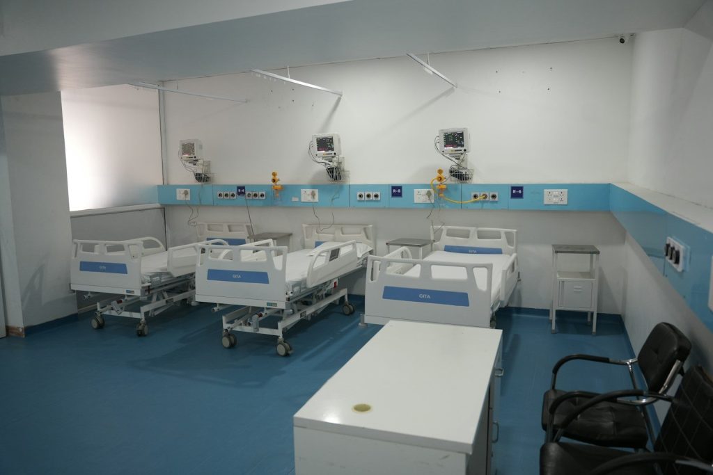 Hospital room with three beds and medical equipment