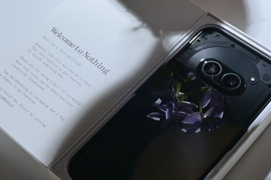 A cell phone in a box with a flower in it