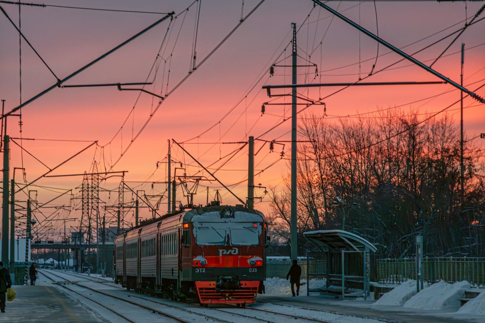 Train moving through snowy landscape at sunset