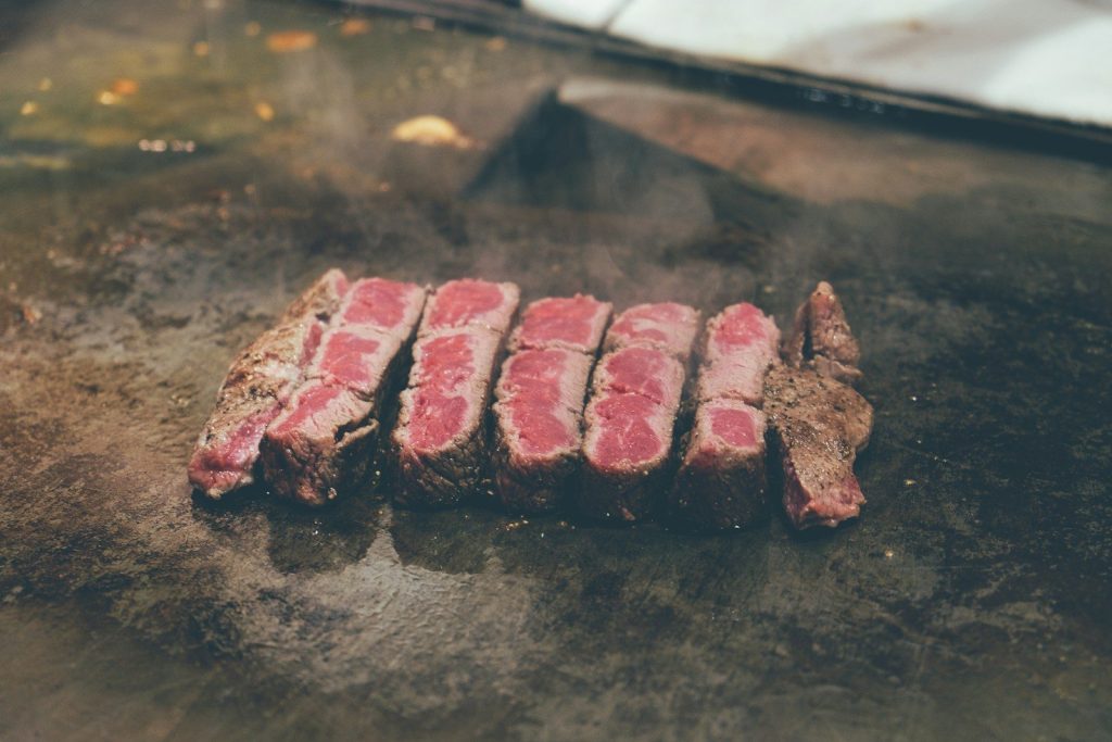 sliced meat on black surface