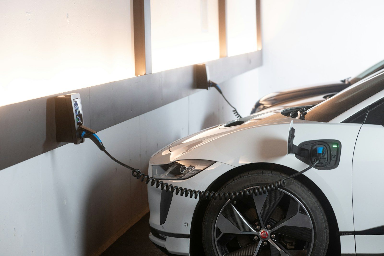White electric car charging at a station.