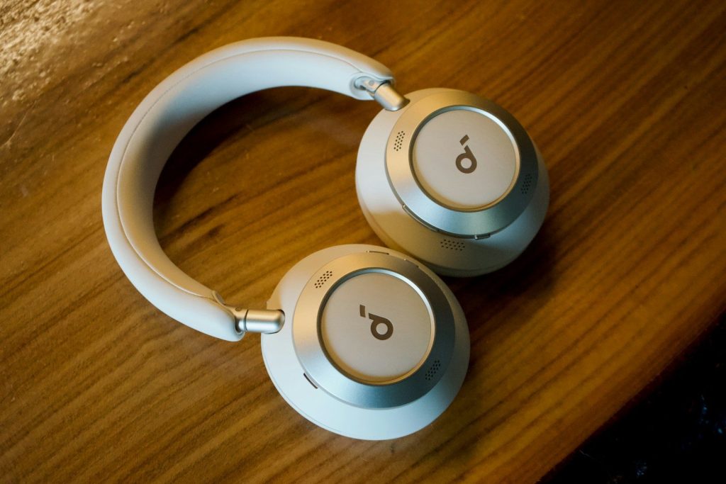 White and silver headphones resting on a wooden table