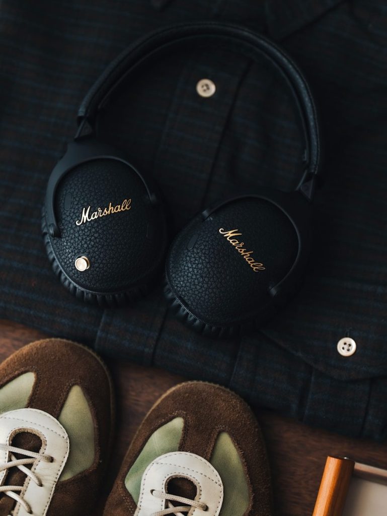 Marshall headphones, a dark shirt, and brown shoes.