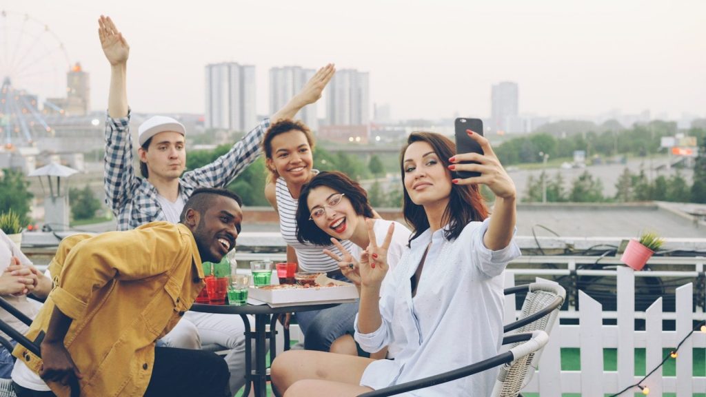 Group of friends taking a selfie on a rooftop.