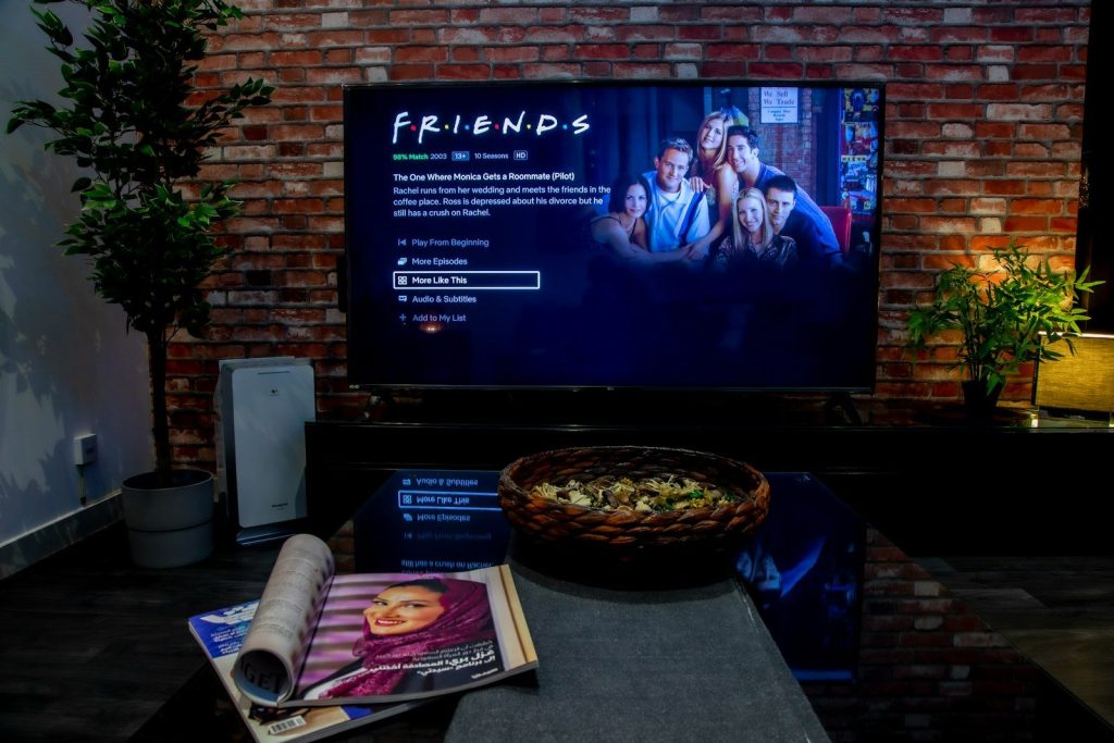 black flat screen tv turned on near brown brick wall