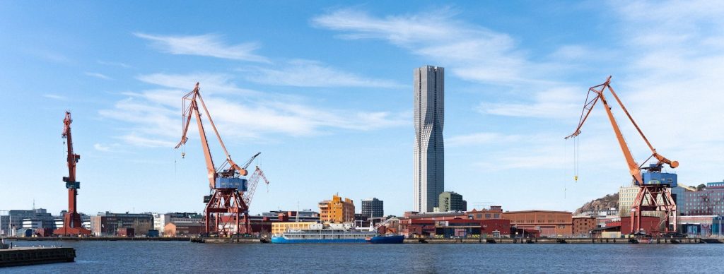 Harbor with cranes and tall building under construction building.