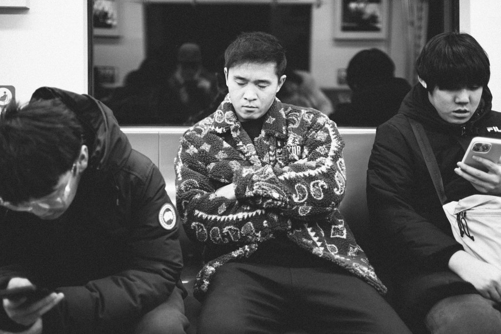 a black and white photo of three people on a train