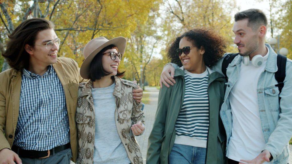 Four friends walking together in a park