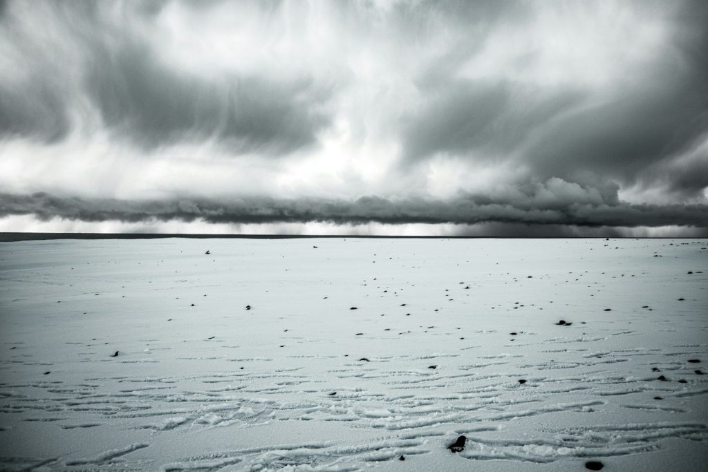 a black and white photo of a snow covered field