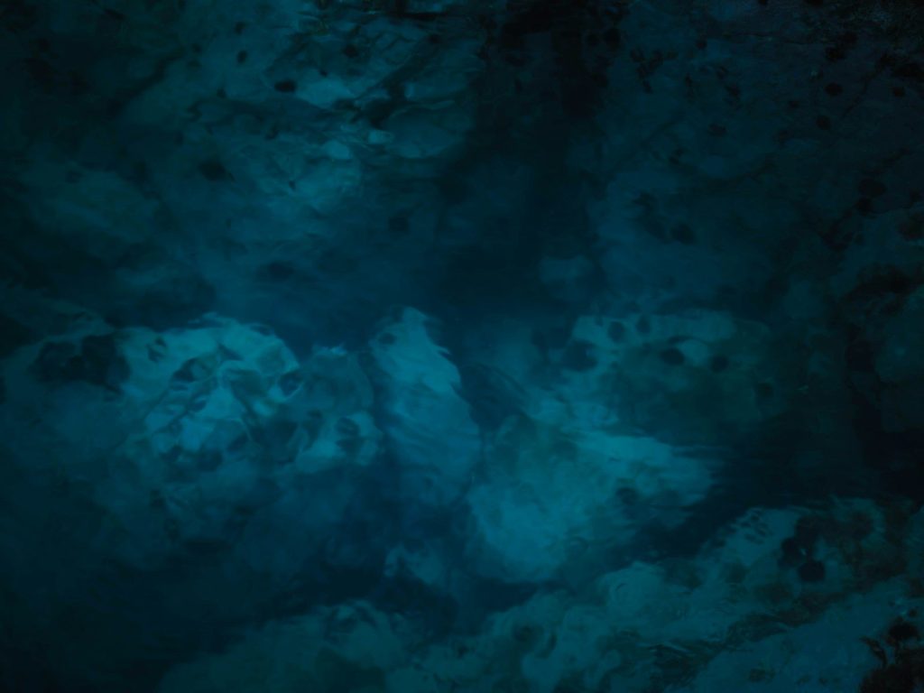 A dark room with a blue light coming from the ceiling