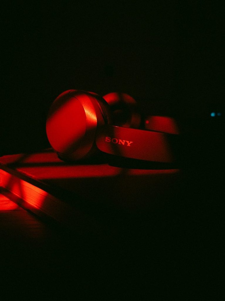 Red sony headphones illuminated in darkness
