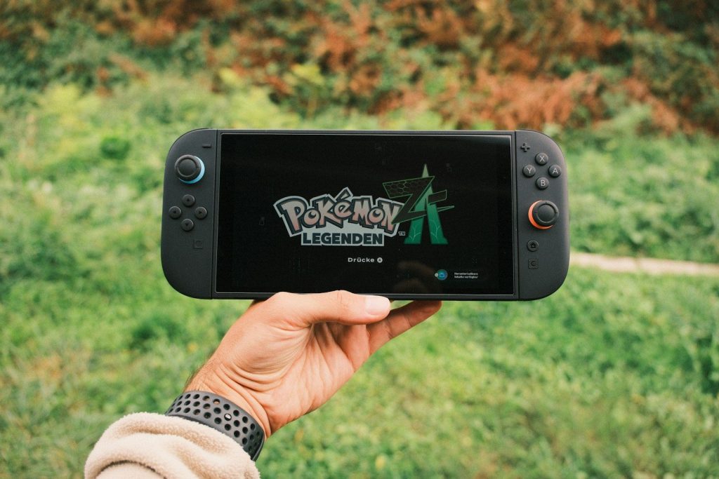 Hand holding a nintendo switch playing pokémon legends
