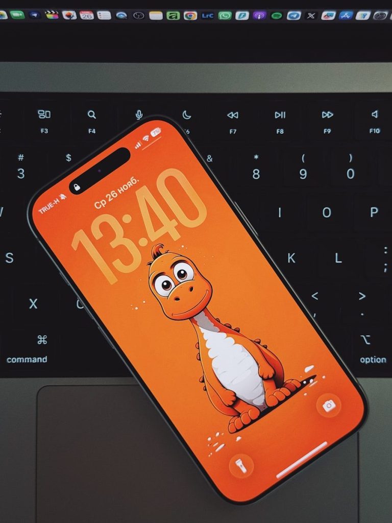 Smartphone with cartoon dinosaur wallpaper on keyboard