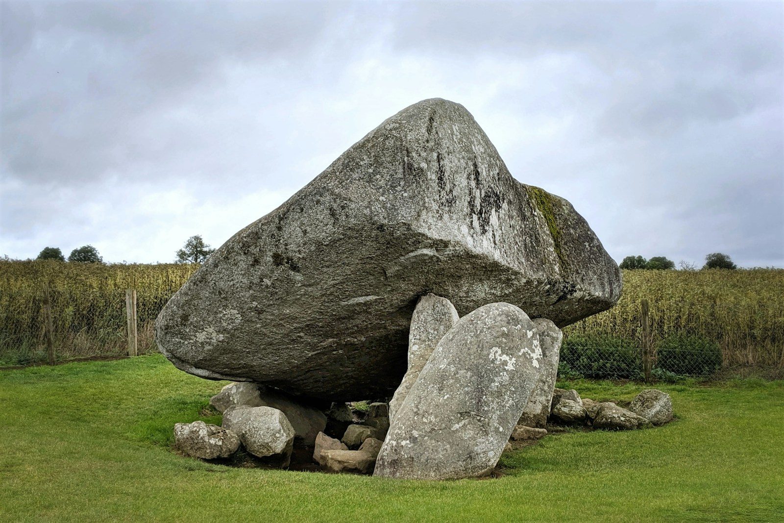 Ancient stone dolmen structure under a cloudy sky.