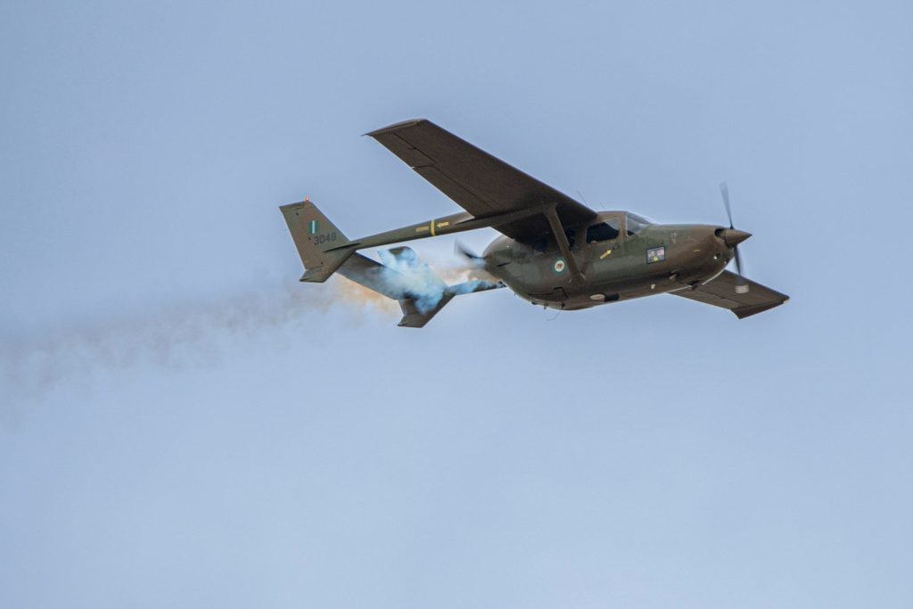 a plane with smoke coming out of it flying in the sky
