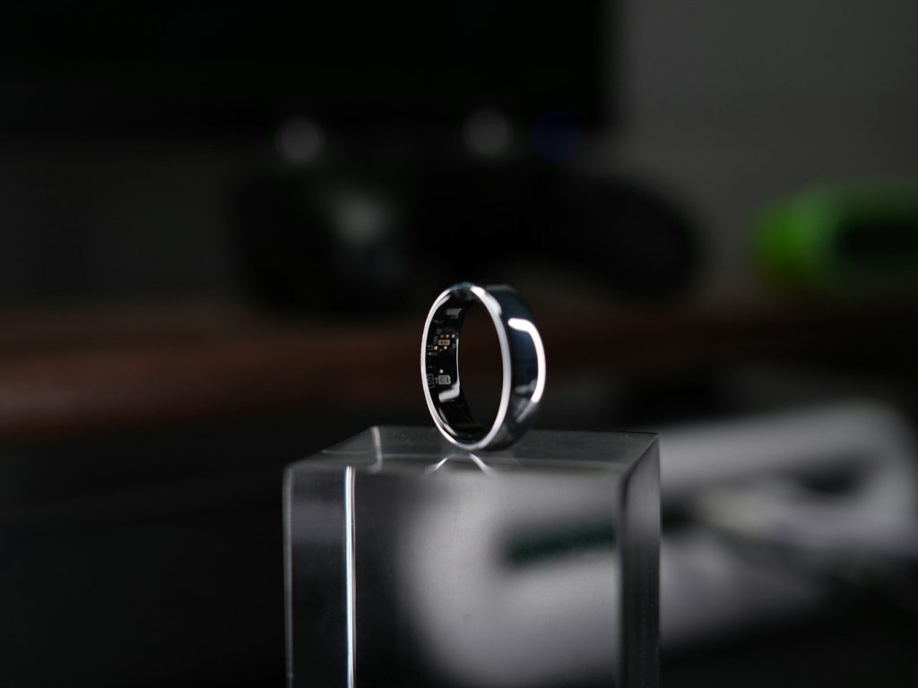 A smart ring is displayed on a clear block.