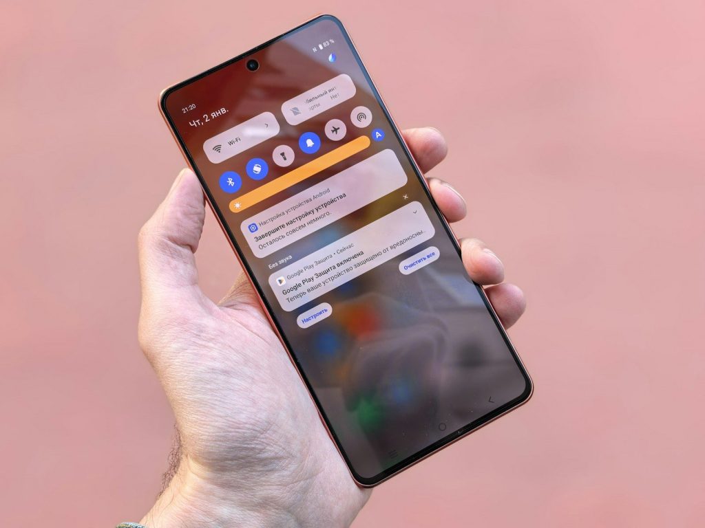 A hand holds a smartphone showing notifications.