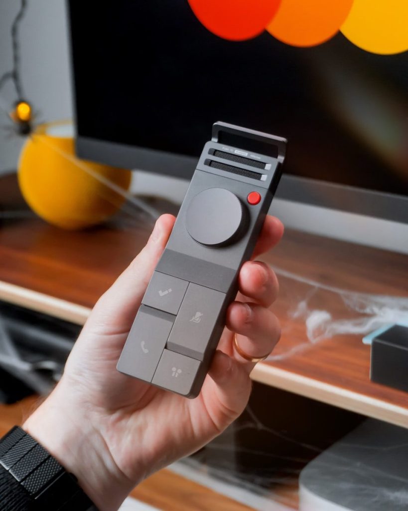 Hand holding a modern gray remote control