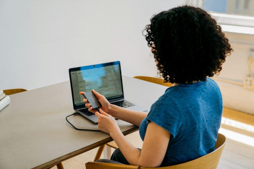 A woman sitting at a table using a laptop computer