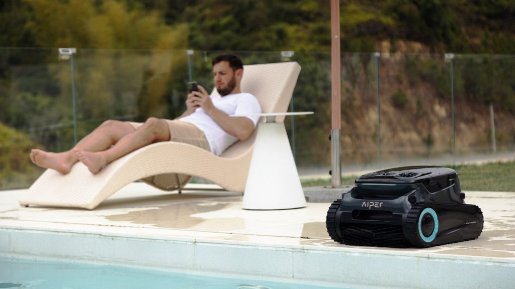 A man relaxing by the pool, using his phone.