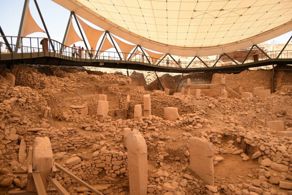 Ancient ruins with stone pillars under a canopy.