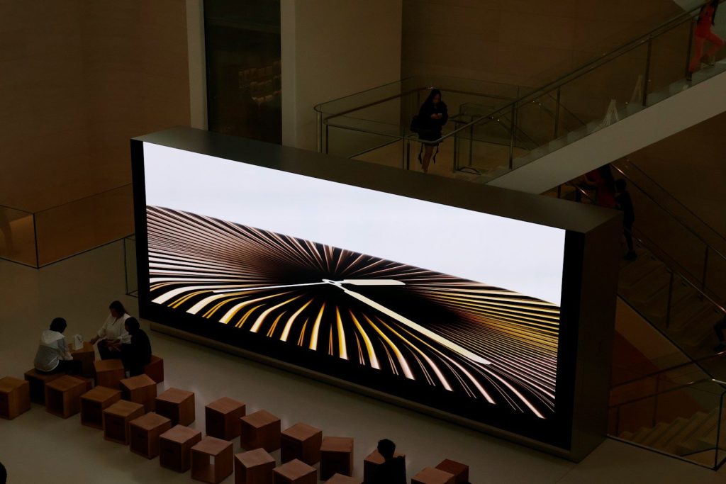 Large screen displays abstract graphic art.
