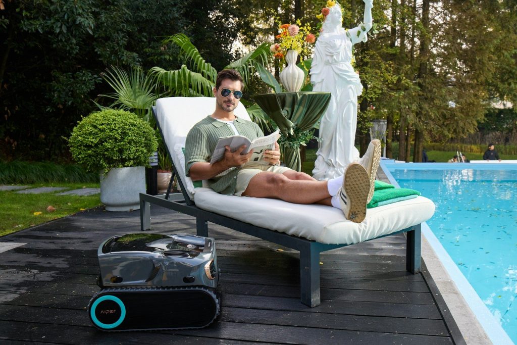 Man relaxes by the pool, reading a book.