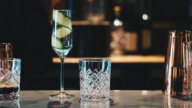 three glasses of alcohol on a bar with a view of a city