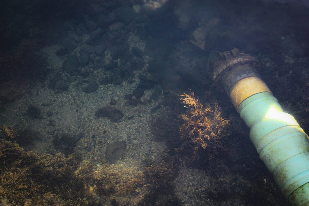 A pipe laying on the ground in the water