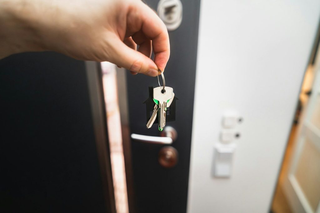 A person is holding a key to a door